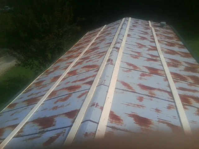 Rusted metal roof panels with new wood purlins before replacement — Storm Damage Roof Repair in Stevenson by Roofing Brothers